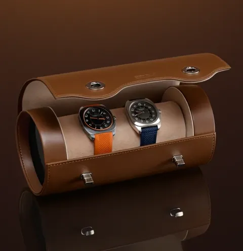 Кейс раскрыт: внутри бежевая замшевая подушка и двое часов на ней. Видно, что вмещается ровно две пары и между ними есть