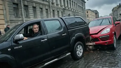 Пикап таранит кроссовер сбоку, водитель пикапа виден в окне. Столкновение показано в одном кадре, без монтажной склейки.