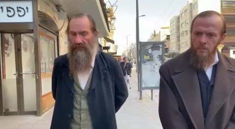 Кадр ближе к лицам: борода, взгляд, воротник. Портретная точность на уровне, при котором персонажи узнаются без подписи.