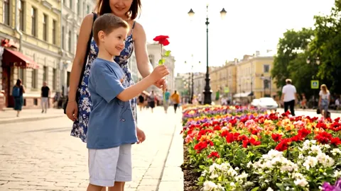 Мальчик протягивает сорванный цветок. Футболка в движении: рукав пошёл вверх, видно, что он свободный и не перетягивает 